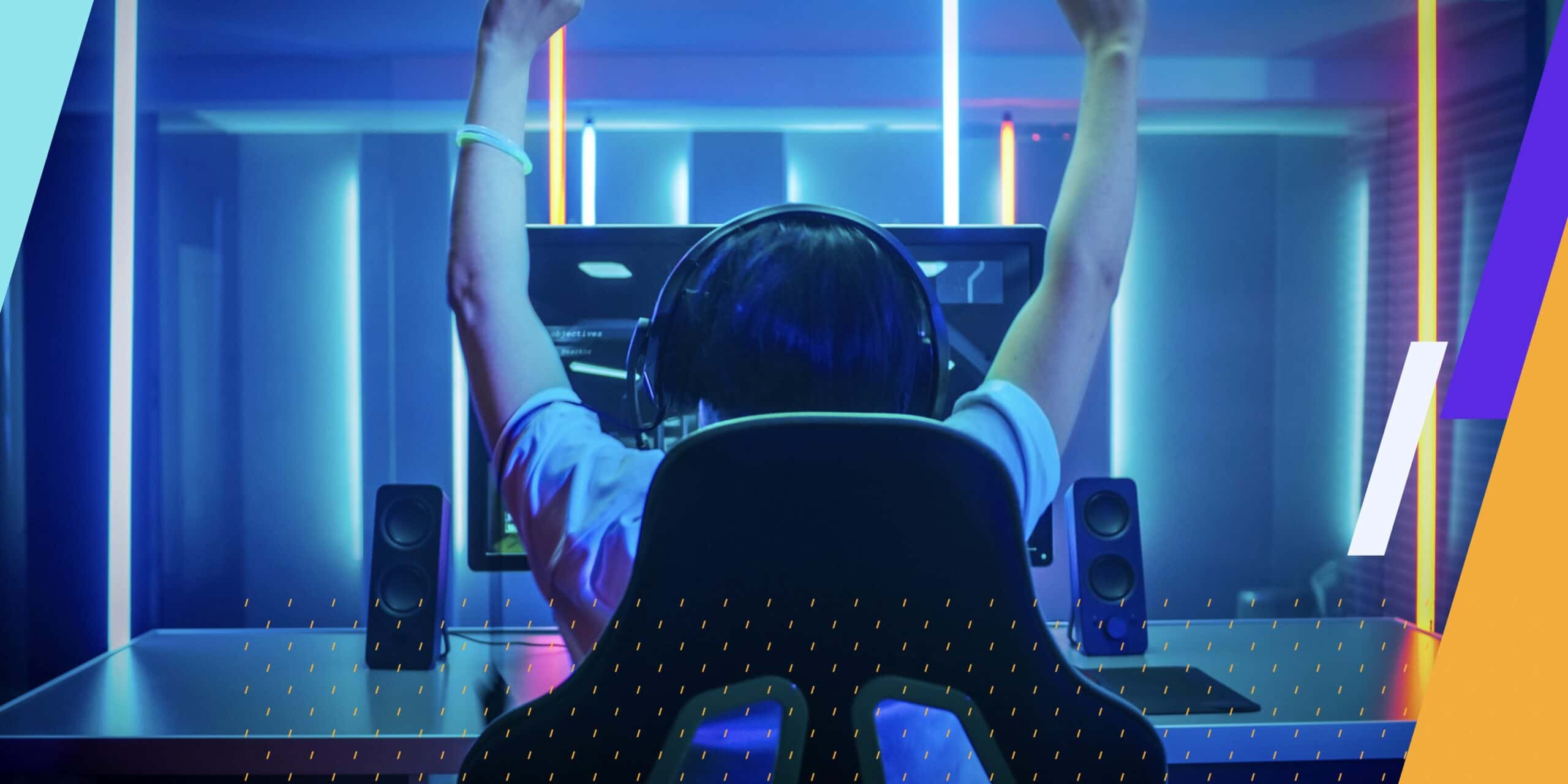 Person sitting in gaming chair in front of display with arms thrown above their head in victory