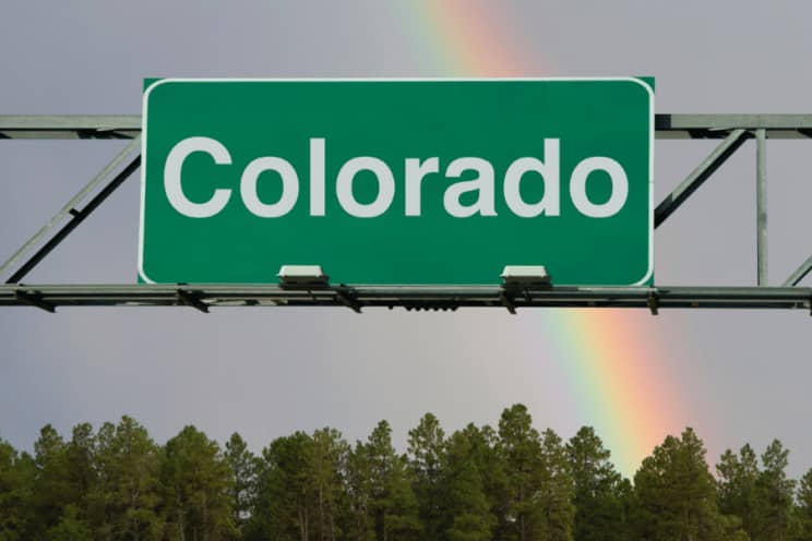A sign above a roadway that reads "Colorado". It is a green way finding sign with white text.